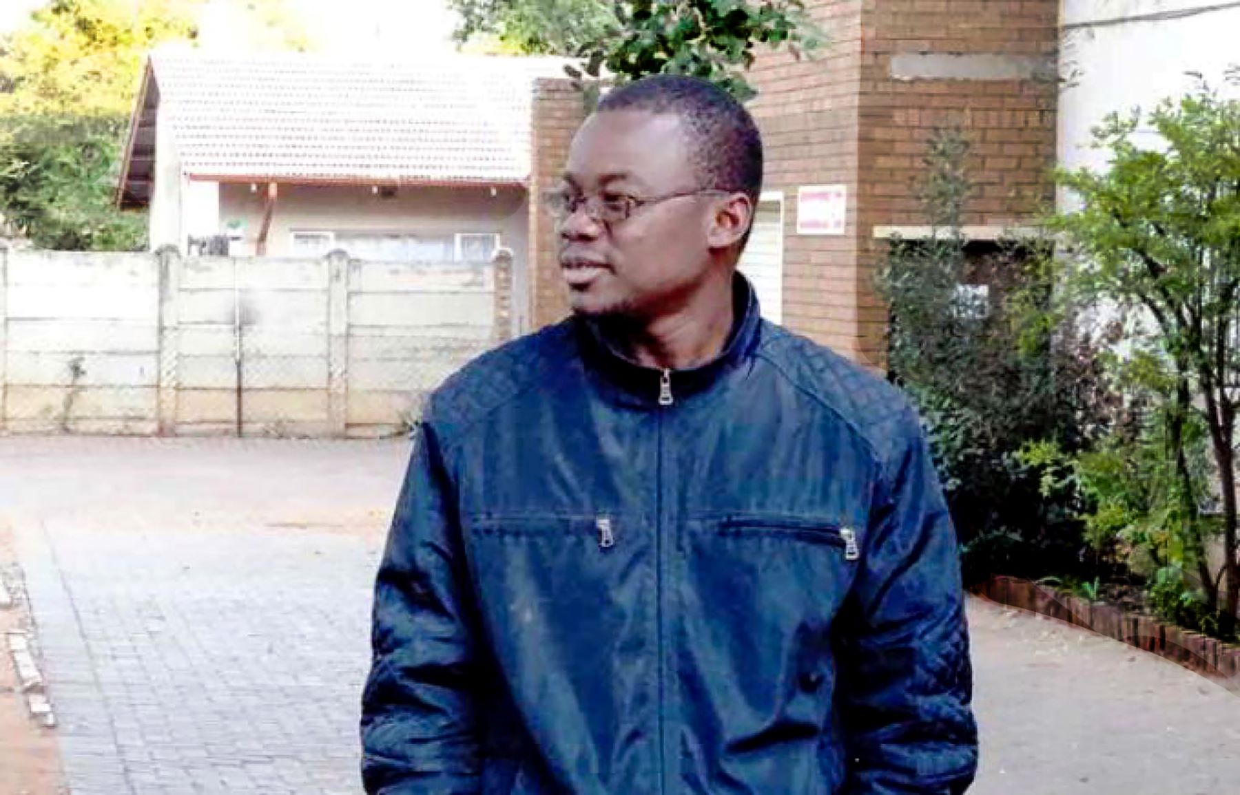 Deacon Hermann Hahunan Djumini wears glasses and a blue jacket