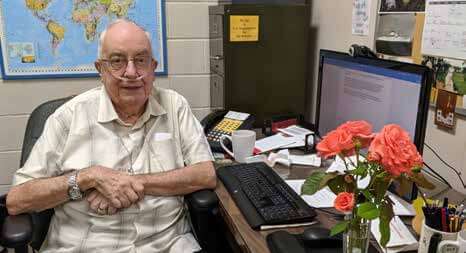 Fr Joe Bragotti sits at his desk