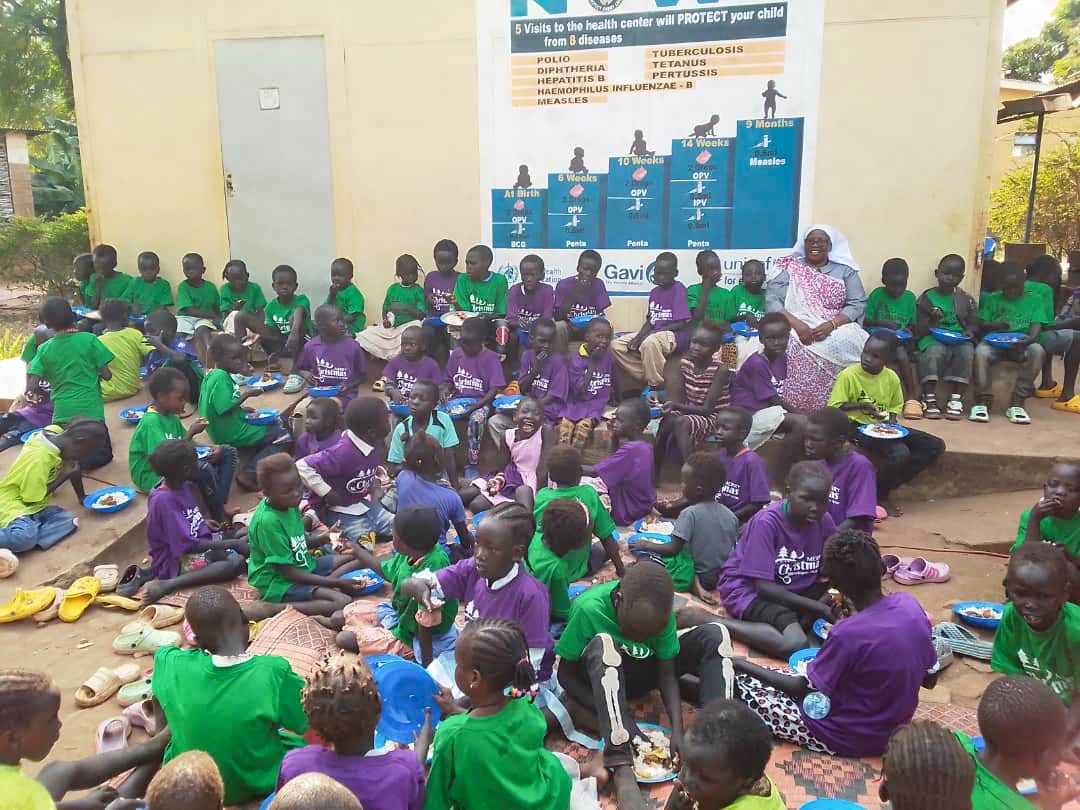 African Children gather outside with Sr Rosemary. They are all wearing new shirts she bought them for Christmas.