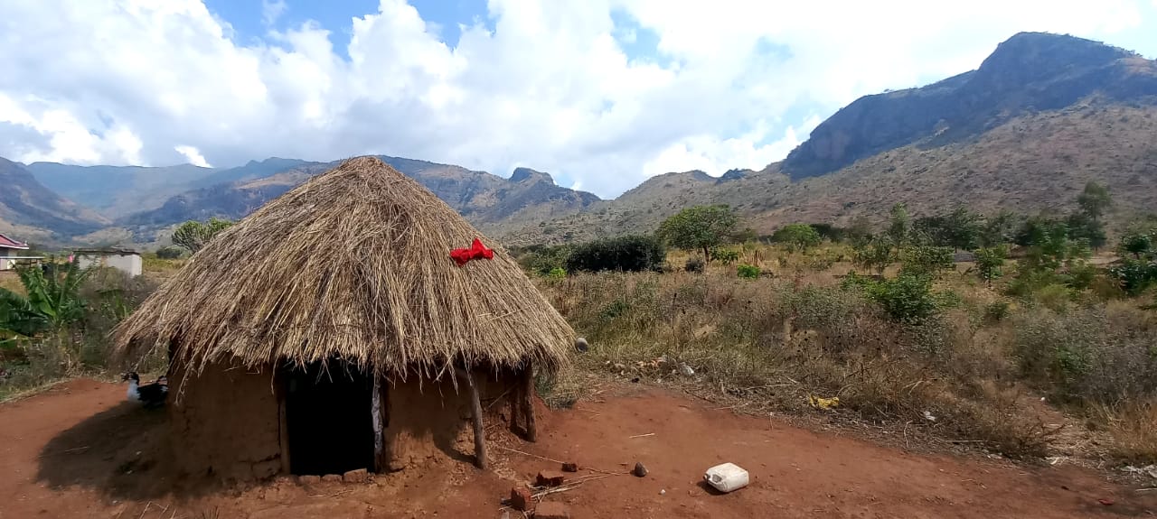 A traditional Kenyan hut with a blue sky background